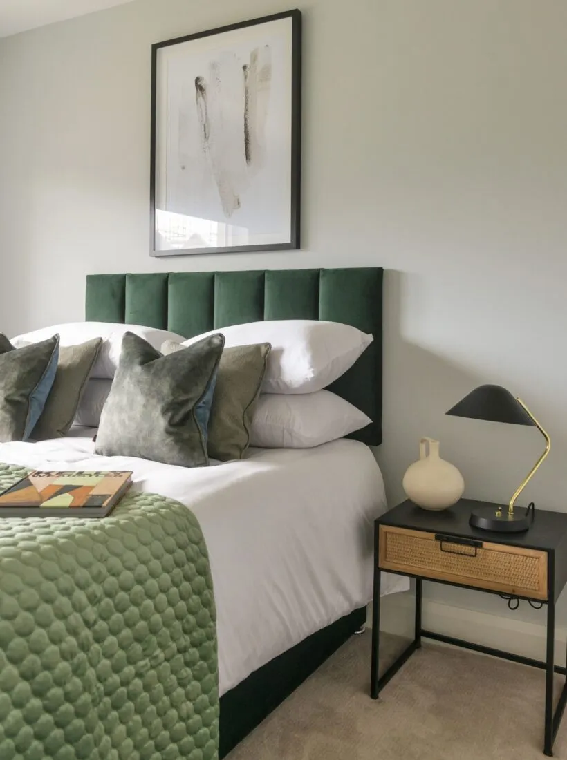 green and white bed with stacked cushions